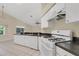 Bright kitchen area featuring white cabinetry, and appliances, with a view overlooking the living space at 22802 Roderick Dr, Land O Lakes, FL 34639