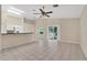 Open living room with tiled floors that connects to the kitchen and features access to the lanai at 22802 Roderick Dr, Land O Lakes, FL 34639