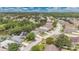 Aerial view of a well-maintained neighborhood with lush green trees and lake surrounding the community at 22802 Roderick Dr, Land O Lakes, FL 34639