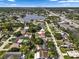 Expansive aerial view of a residential neighborhood showcasing a property with mature trees and a nearby lake at 9033 3Rd N St, St Petersburg, FL 33702