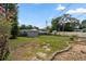 Backyard showcasing a large green lawn, a storage shed, and a variety of garden beds at 9033 3Rd N St, St Petersburg, FL 33702