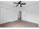 Bedroom with wood-look floors, ceiling fan, and white closet doors, creating a spacious and serene atmosphere at 9033 3Rd N St, St Petersburg, FL 33702