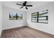 Inviting bedroom features sleek flooring, new paint, ceiling fan, and abundant natural light from two windows at 9033 3Rd N St, St Petersburg, FL 33702