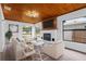 Staged living room featuring fireplace, wood paneled ceiling and hardwood floors at 9033 3Rd N St, St Petersburg, FL 33702