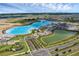 Aerial view of a community featuring a lagoon, recreation facilities, and nicely landscaped areas at 10815 Laxer Cay Loop, San Antonio, FL 33576