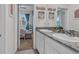 Bright bathroom featuring double sinks with granite counters and a doorway view into an adjacent bedroom at 10815 Laxer Cay Loop, San Antonio, FL 33576