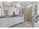 Bathroom featuring double vanity, framed mirror, and glass shower with beige tile at 10815 Laxer Cay Loop, San Antonio, FL 33576