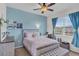 Cozy bedroom features a pastel blue accent wall, complemented by light-colored furnishings and ample natural light at 10815 Laxer Cay Loop, San Antonio, FL 33576