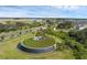 Attractive community entrance with lush green spaces, unique architecture, and water feature at 10815 Laxer Cay Loop, San Antonio, FL 33576