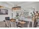 This open dining room features a modern light fixture and flows into the spacious living room at 10815 Laxer Cay Loop, San Antonio, FL 33576