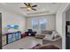 Cozy living room featuring tile flooring, tray ceiling, a ceiling fan and natural light at 10815 Laxer Cay Loop, San Antonio, FL 33576