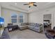 Bright living room features tile floors, a gray couch, and two windows with views to the street at 10815 Laxer Cay Loop, San Antonio, FL 33576