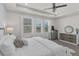 Bright bedroom featuring tray ceilings, recessed lights, large windows, and neutral decor at 10815 Laxer Cay Loop, San Antonio, FL 33576