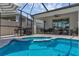 Beautiful screened in pool area with brick patio flooring, dining area, and cooking area at 10815 Laxer Cay Loop, San Antonio, FL 33576