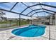 Beautiful screened pool and patio area with a lake view, grill, and sun umbrella at 10815 Laxer Cay Loop, San Antonio, FL 33576