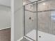 Bathroom boasting an updated tiled walk-in shower with glass door, and open doorway at 3137 Marine Grass Dr, Wimauma, FL 33598