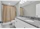 Bathroom with a double sink vanity with granite countertop and shower with tan curtain at 3137 Marine Grass Dr, Wimauma, FL 33598