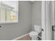 Bathroom displaying toilet, vanity, and a bright window with neighborhood view at 3137 Marine Grass Dr, Wimauma, FL 33598