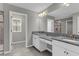 Bathroom featuring double vanity with granite countertop, large mirror, and walk-in shower for a spa-like experience at 3137 Marine Grass Dr, Wimauma, FL 33598