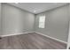 Bedroom with wood-look flooring, neutral walls, and natural light from a window at 3137 Marine Grass Dr, Wimauma, FL 33598