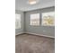 This bedroom has neutral walls, plush carpet, and two windows for natural light at 3137 Marine Grass Dr, Wimauma, FL 33598