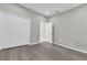 Bedroom featuring wood-look flooring, neutral walls, closet and open doorway at 3137 Marine Grass Dr, Wimauma, FL 33598