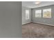 This bedroom has neutral walls, plush carpet, three windows, and a ceiling light at 3137 Marine Grass Dr, Wimauma, FL 33598