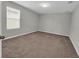 This bedroom features neutral walls, plush carpet, and a window for natural light at 3137 Marine Grass Dr, Wimauma, FL 33598