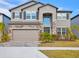 Charming two-story home featuring stone accents, a well-manicured lawn, and a two-car garage at 3137 Marine Grass Dr, Wimauma, FL 33598