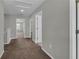 This hallway has neutral walls, carpet, white trim, and access to other rooms at 3137 Marine Grass Dr, Wimauma, FL 33598