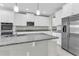 Modern kitchen featuring granite countertops, stainless steel appliances, and white cabinetry at 3137 Marine Grass Dr, Wimauma, FL 33598