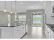 A modern kitchen featuring a central island, granite counters, stainless appliances and lake views at 3137 Marine Grass Dr, Wimauma, FL 33598