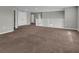 Open living room area with neutral walls and carpet and an adjacent stairway at 3137 Marine Grass Dr, Wimauma, FL 33598