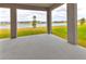Covered patio with concrete floor, columns, and a view of the lake and lawn at 3137 Marine Grass Dr, Wimauma, FL 33598