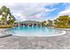 Community zero entry pool and clubhouse surrounded by landscaping and sunny skies at 3137 Marine Grass Dr, Wimauma, FL 33598