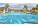 Outdoor pool surrounded by palm trees and lounge chairs at 3137 Marine Grass Dr, Wimauma, FL 33598
