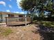 Backyard deck with wooden railings offers a cozy space to enjoy the outdoors at 1079 Woodbrook S Dr, Largo, FL 33770
