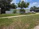A cozy home featuring an inviting front yard, lush trees, and a private driveway at 1079 Woodbrook S Dr, Largo, FL 33770