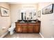 Bathroom featuring a dual sink vanity, tiled flooring, a toilet and framed wall art at 3009 Ridgevale Cir, Valrico, FL 33596