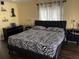 Bedroom with a zebra-striped comforter, modern black furniture, and shelves creating a contemporary space at 3009 Ridgevale Cir, Valrico, FL 33596