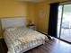 Bedroom featuring a stylish bed, yellow walls, and access to the screened-in porch providing a peaceful retreat at 3009 Ridgevale Cir, Valrico, FL 33596