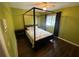 Bright bedroom featuring a four-poster bed, green walls, and hardwood floors, offering a serene retreat at 3009 Ridgevale Cir, Valrico, FL 33596
