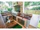 Outdoor kitchen featuring stainless steel appliances, stone finishes, and a small refrigerator at 3009 Ridgevale Cir, Valrico, FL 33596