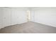 Bright bedroom with neutral walls and carpet, sliding closet door, and doorway to the kitchen area at 3550 Moscato Dr, Brooksville, FL 34602