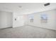 Spacious bonus room featuring neutral carpet, white walls, and natural light from windows at 3550 Moscato Dr, Brooksville, FL 34602