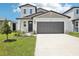 Charming two-story home featuring a modern exterior, well-manicured lawn, and a spacious driveway with an attached garage at 3550 Moscato Dr, Brooksville, FL 34602