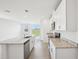 An open kitchen with granite countertops, stainless steel appliances, and sliding glass doors leading to the backyard at 3550 Moscato Dr, Brooksville, FL 34602