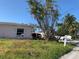 View of the front yard and exterior, showing the house number with a sunny sky overhead at 365 145Th E Ave, Madeira Beach, FL 33708