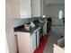 Damaged kitchen featuring white cabinets, dark countertops and appliances at 365 145Th E Ave, Madeira Beach, FL 33708
