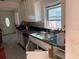 Damaged kitchen featuring white cabinets, a stainless sink, and granite countertops at 365 145Th E Ave, Madeira Beach, FL 33708